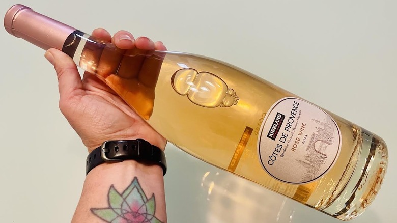 Hand holding bottle of Kirkland Signature Côtes De Provence Rosé