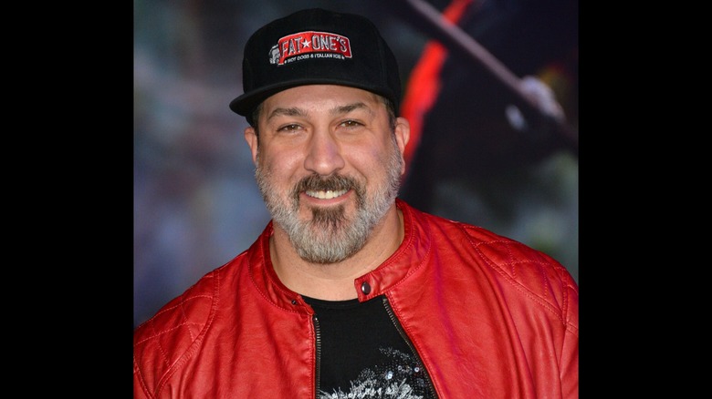 Joey Fatone in a red jacket and Fat One's hat