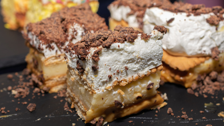 A layered chocolate dessert with whipped cream and cream cheese and shortbread crust