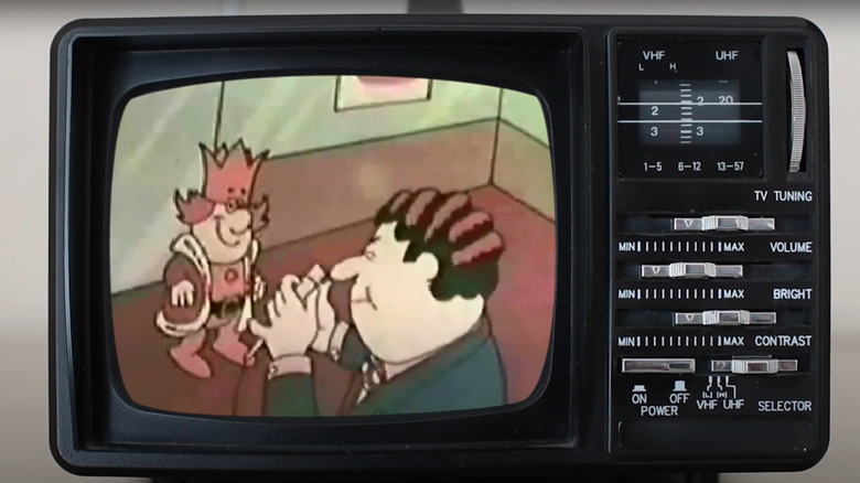 A version of the cartoon King with red hair and a royal red outfit