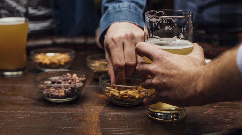 hands with bar nuts and beers