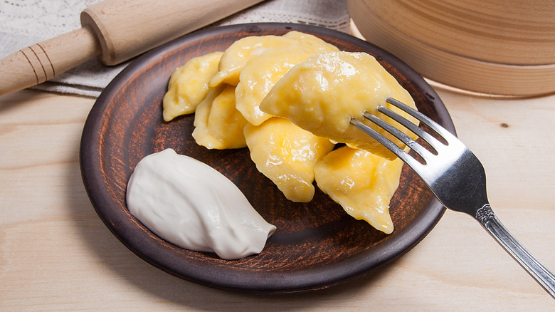 Pierogi on fork with bowl