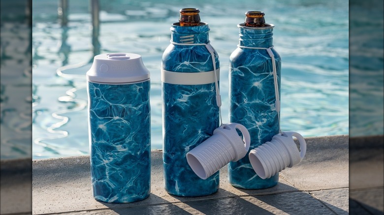 A CanKeeper with two BottleKeepers in an aqua pattern sitting by a pool