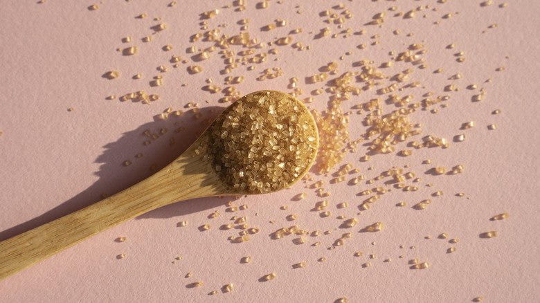 Brown cane sugar in a wooden spoon