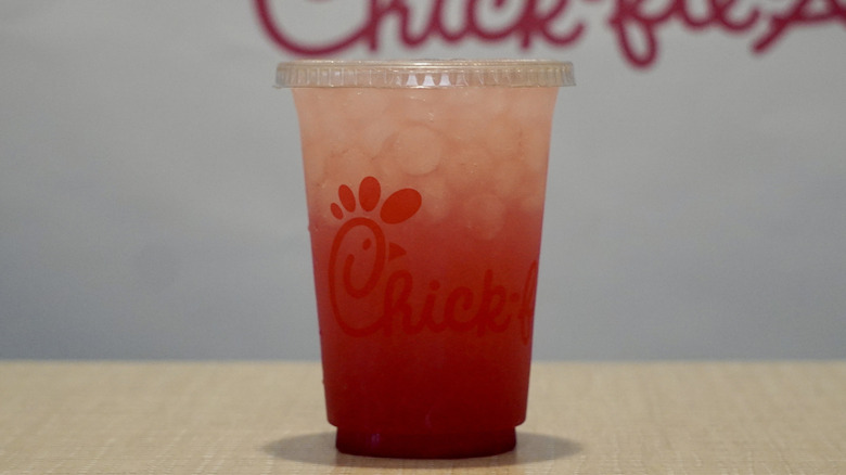 Cherry Berry Lemonade on a tan table in front of a white Chick-fil-A step and repeat