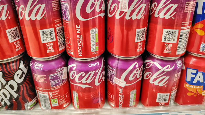 Cans of Cherry Coca-Cola on display on a store shelf