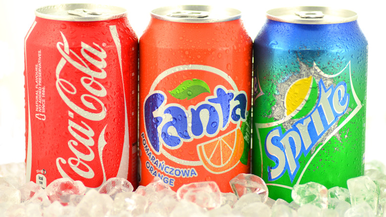 Coca-Cola, Fanta, and Sprite cans on ice