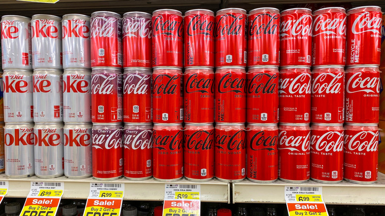 Coke cans on display at a grocery store