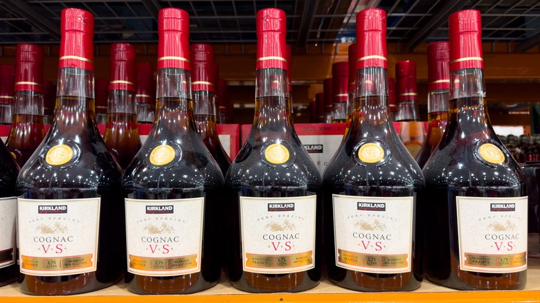 A view of a grocery store shelf filled with bottles of cognac