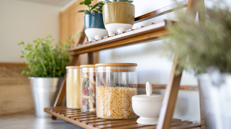 A double-decker shelf with dry goods and plants
