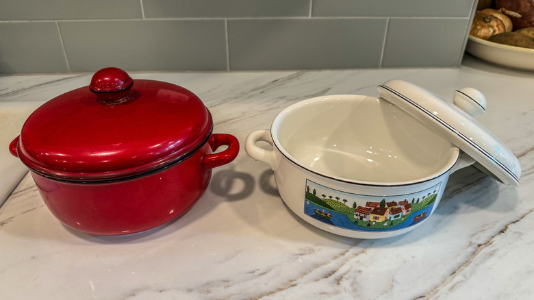 enamel stock pots on a marble countertop