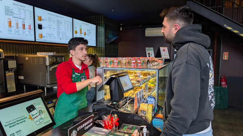 A Starbucks barista takes an order at the till