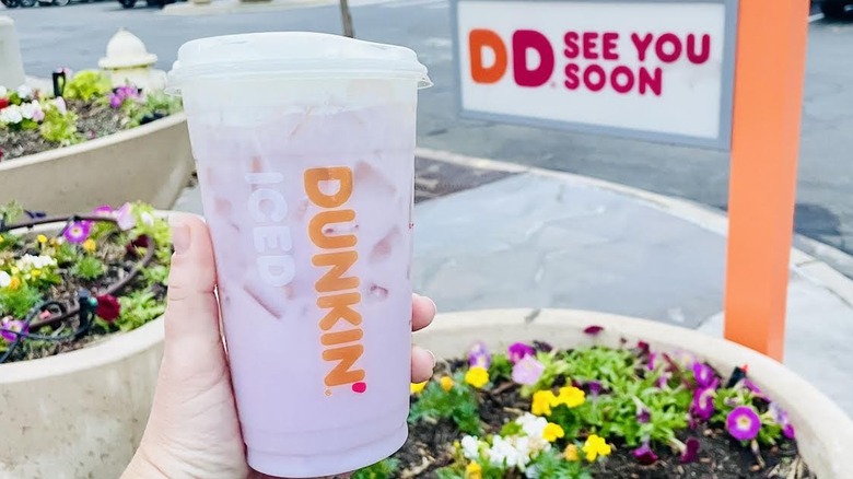 Hand holding Sabrina's Strawberry Daydream Refresher in front of Dunkin' drive-thru exit