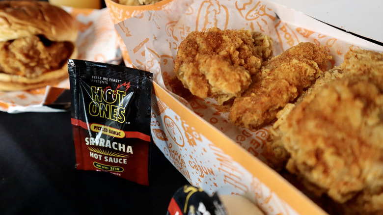 Hot Ones sauce packet next to chicken