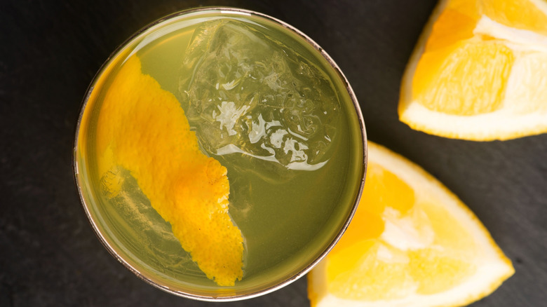 A clarified milk punch is viewed from overhead, with lemon wedges nearby