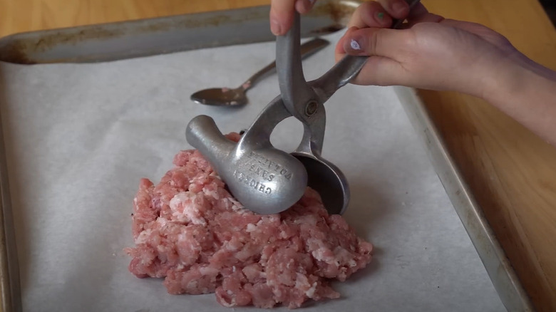 ground pork being scooped into city chicken mold