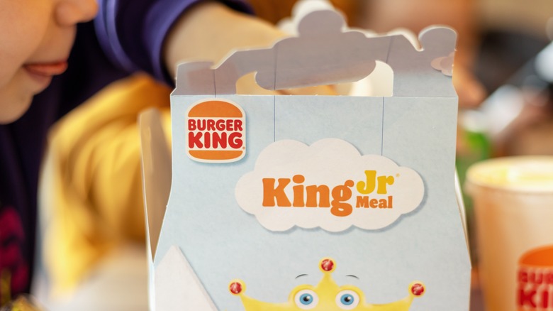 Kid hovers over Burger King Jr. meal package