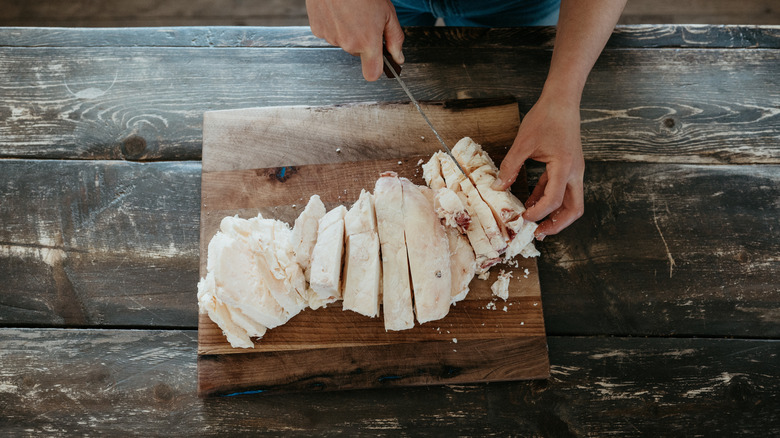 Homemade solid beef tallow being sliced on a cutting board