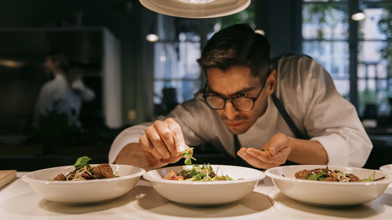 A chef carefully plating food.