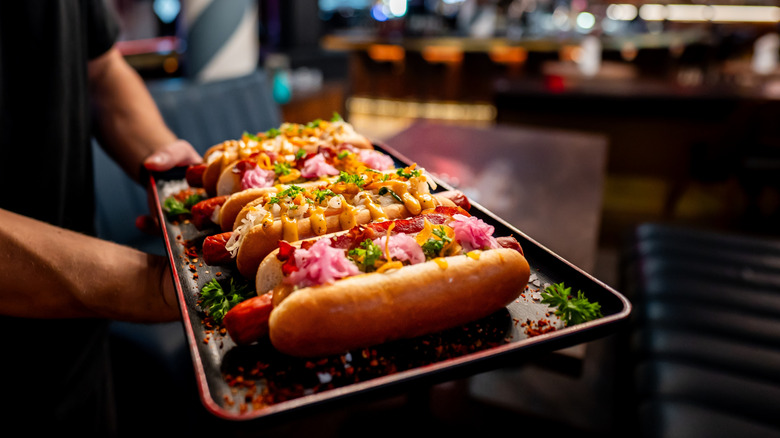 a tray of hot dogs with a variety of toppings
