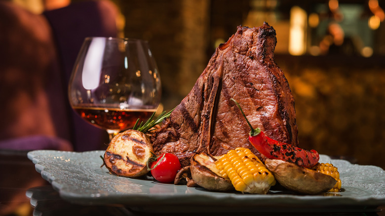 Grilled steak with a glass of whiskey behind it
