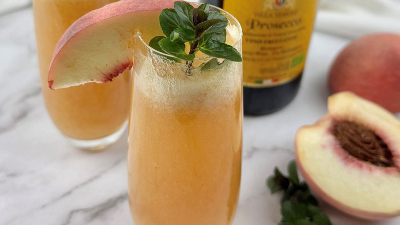 Peach bellini in Champagne flute with mint garnish