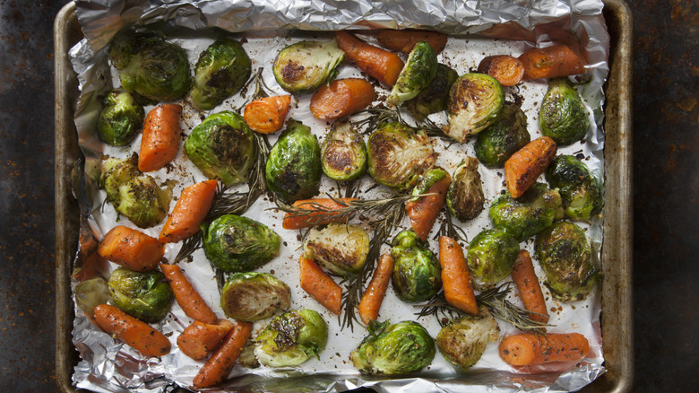 Roasted carrots and Brussels sprouts on a baking sheet