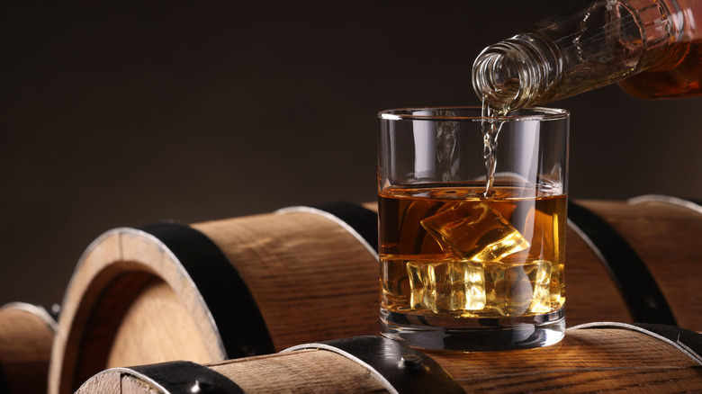 bourbon being poured over ice on a barrel