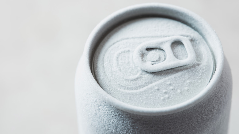A frosted-over soda can sitting on a surface.