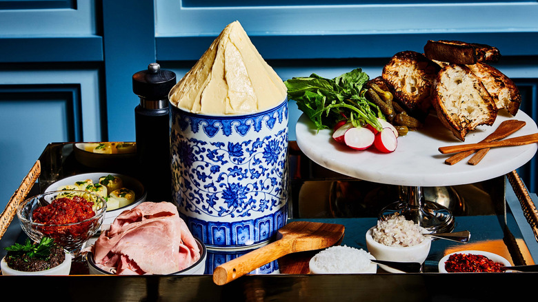The Butter Service Garni tableside bread and butter spread sits on a silver tray at a Quality Bistro booth