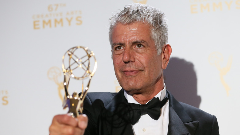 Anthony Bourdain holding award at the Emmys