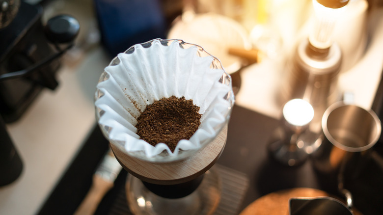 Coffee grounds sit in a coffee filter on top of a pour-over pot