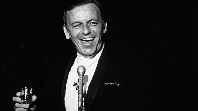 Frank Sinatra performing with a drink in his hand