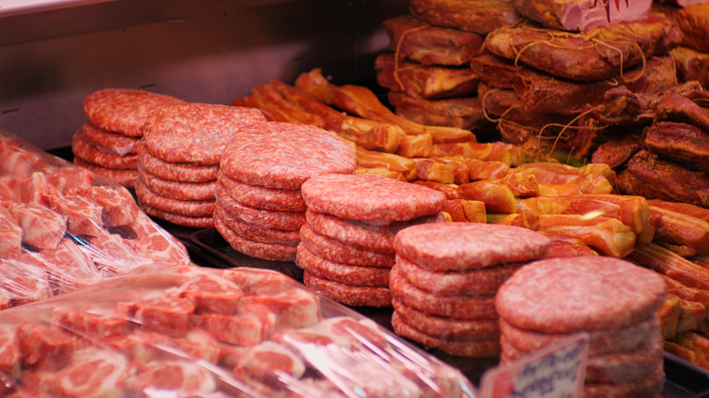 Stacks of burger patties in the meat section of a deli