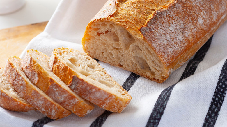 A loaf of sourdough bread with several slices cut from it.