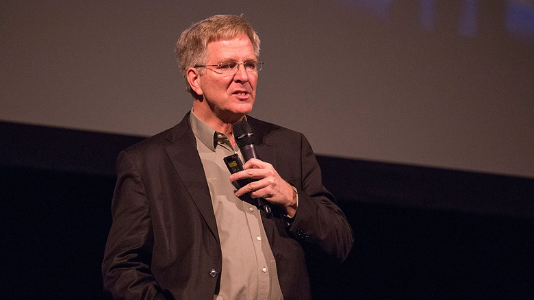 Rick Steves speaking into a microphone