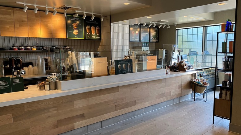 The interior of a Starbucks in at Marriott hotel, with the condiments visible at the hand-off bar