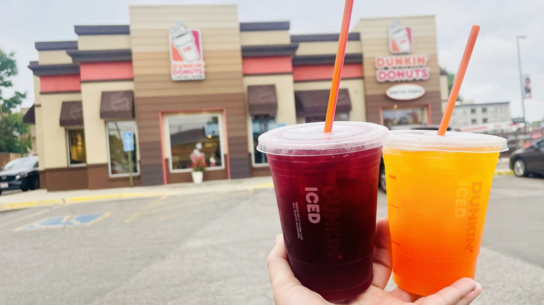 Hand holding new Dunkin' Refreshers in front of store