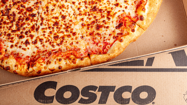 Costco cheese pizza in a cardboard box with Costco logo.