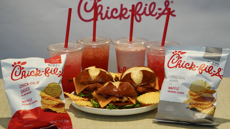 Chick-fil-A Fall 2025 lineup on a tan table in front of a white Chick-fil-A step and repeat
