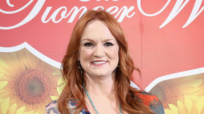 Ree Drummond smiles against a backdrop featuring her brand's logo