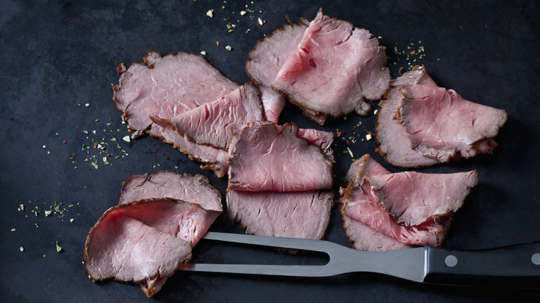 sliced roast beef on a black background