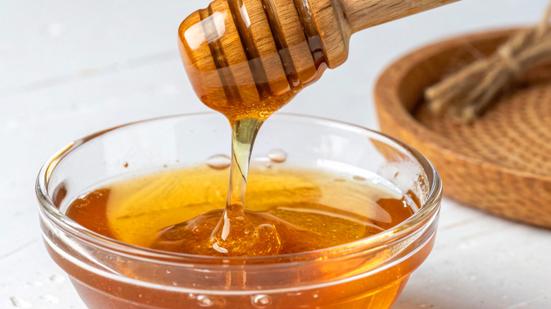 Customer taking a jug of honey from the shelf