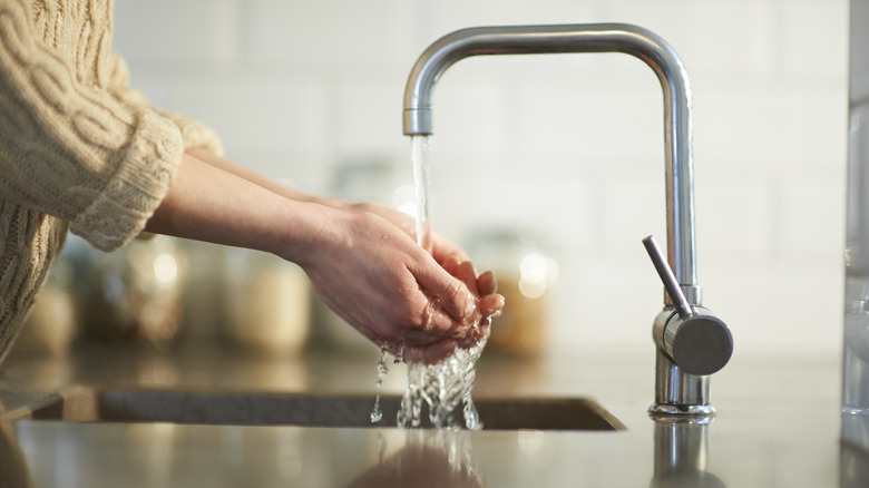 Washing hands at kitchen sink