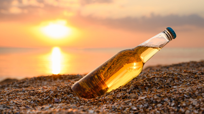 a bottle of beer in the sand