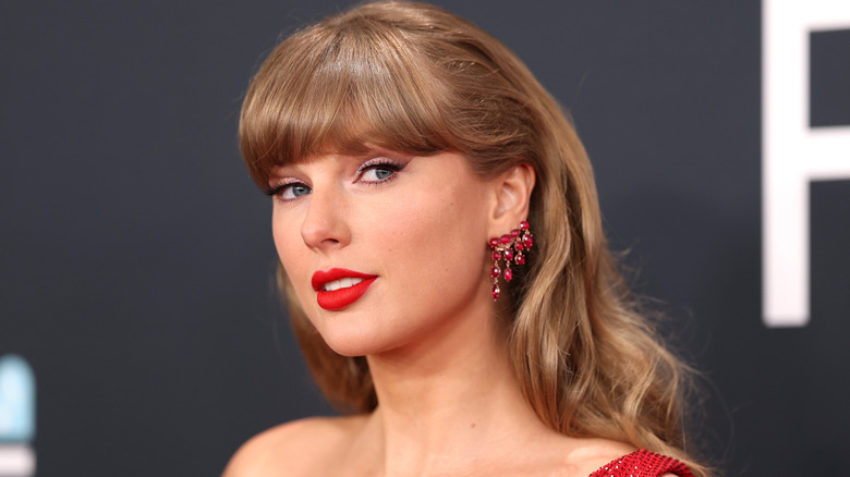 Taylor Swift wears her signature red lipstick on a red carpet