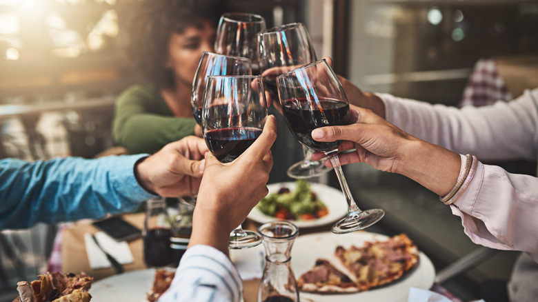 Group of friends clinking wine glasses at a dinner party