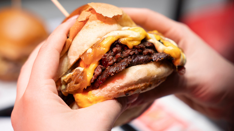 Diner holding burger in hands
