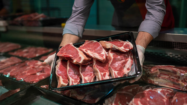 Butcher showing off a collection of different steaks
