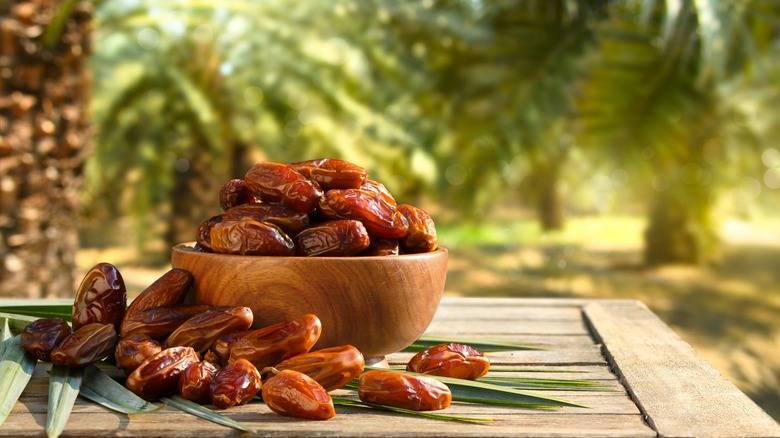 A bowl of dates sits on a table outside